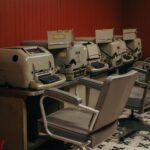 A nostalgic look at a row of vintage typewriters in an office setting with classic chairs.