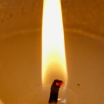 A close-up shot of a candle wick burning brightly, creating a warm ambiance.