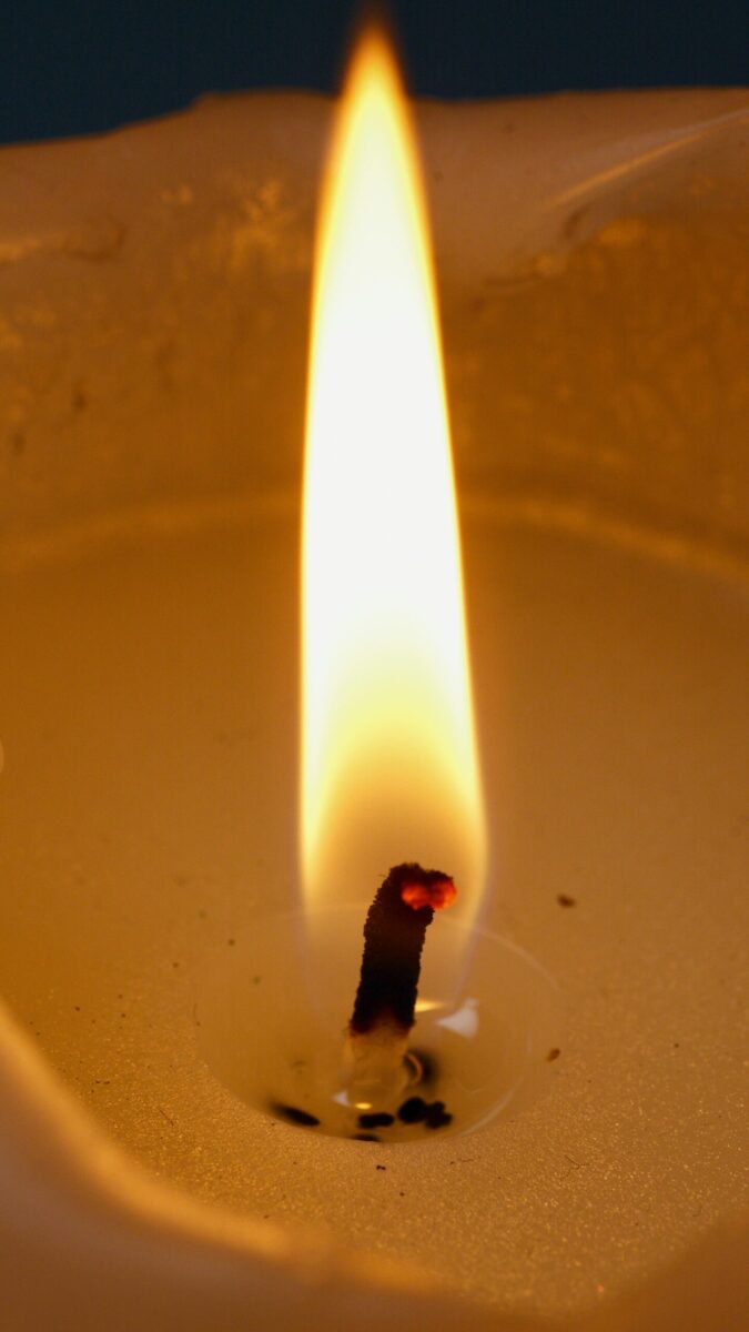 A close-up shot of a candle wick burning brightly, creating a warm ambiance.